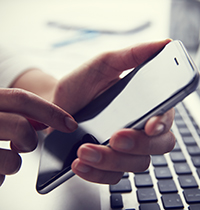 Image of a person using a smartphone and laptop Image of a person using a smartphone and laptop