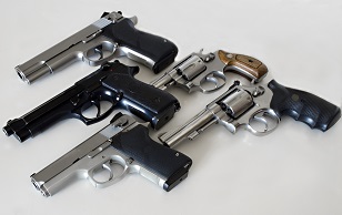 Imagen de cinco armas de fuego sobre una mesa Imagen de cinco armas de fuego sobre una mesa