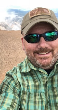Mark standing in front of a natural landscape