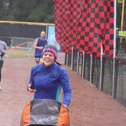 Kristen pushes a stroller while running among other people