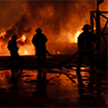 Burning building with firemen responding Burning building with firemen responding