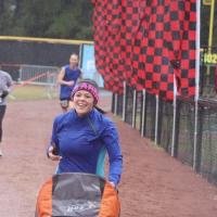 Kristen pushes a stroller while running among other people